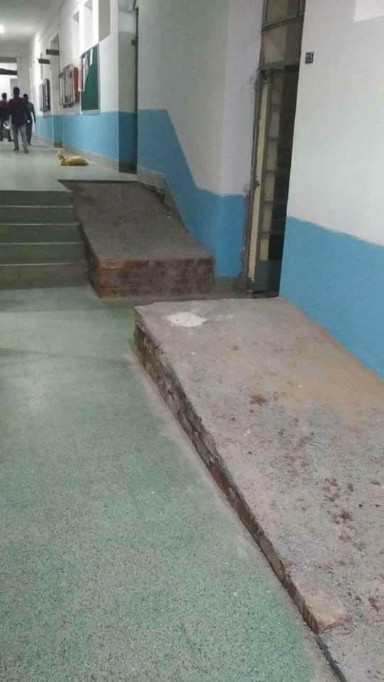 A solid looking wheelchair ramp with a section removed to reach a door on the other side of the ramp.